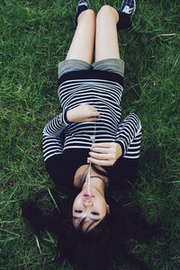 Low section of woman sitting on grassy field