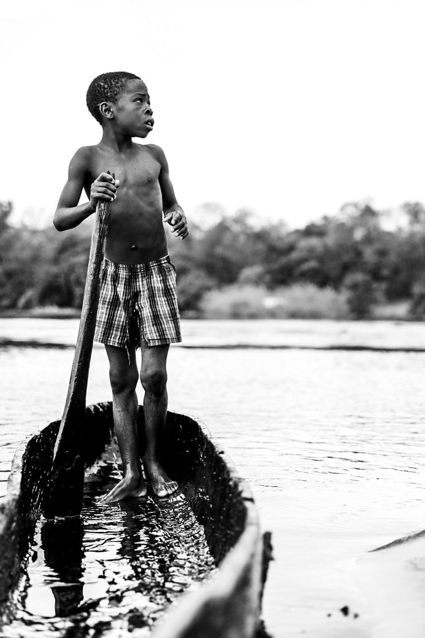 water, childhood, child, one person, boys, nature, standing, real people, day, lake, lifestyles, leisure activity, males, full length, men, shirtless, looking away, outdoors