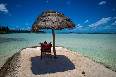 Woman lying on lounge chair at beach