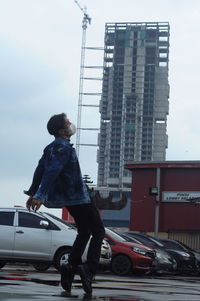 Full length of man standing in city against sky