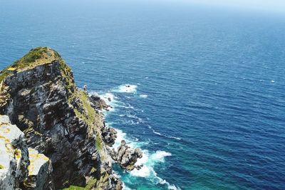 High angle view of rock formation in sea against blue sky