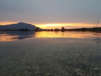 Scenic view of lake against sky during sunset