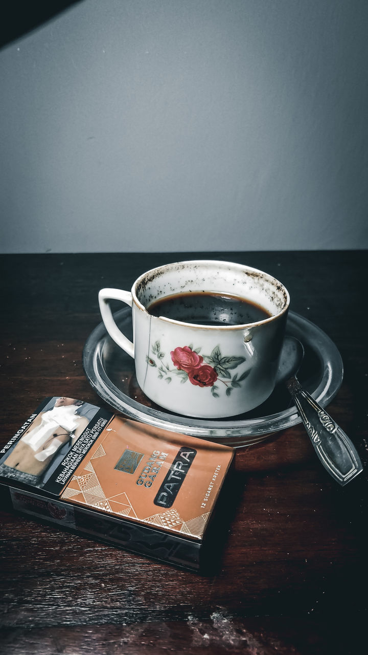 COFFEE CUP ON TABLE AGAINST WALL