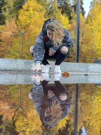 Portrait of young woman standing by railing