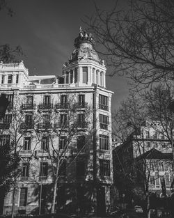 Low angle view of building and trees against sky