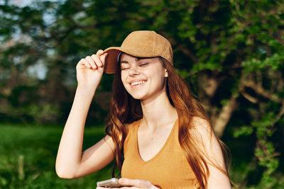 Portrait of young woman standing against plants