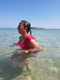 Woman on beach against clear sky