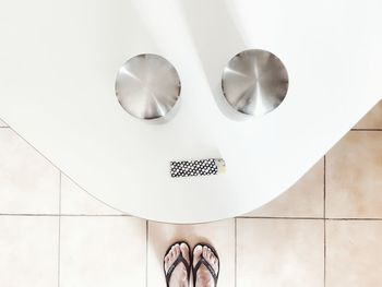 Low section of woman standing on tiled floor