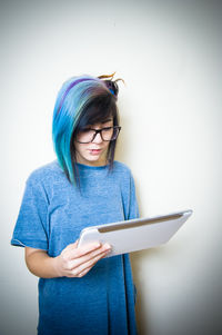 Young woman using mobile phone against white background