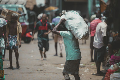 Rear view of people walking on road