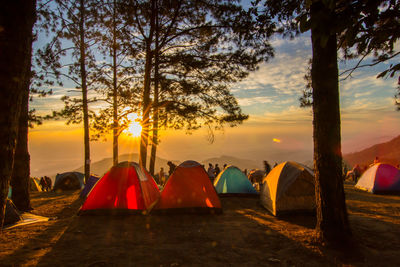 Tent on landscape against sky during sunset