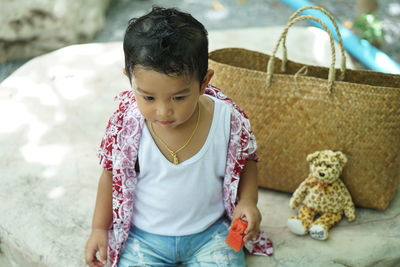 Cute baby boy eating fruit while sitting outdoor