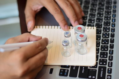 Midsection of person using laptop on table