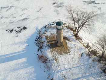 The lake is frozen over with a blue sky but this old landmark still stands watch over the water.