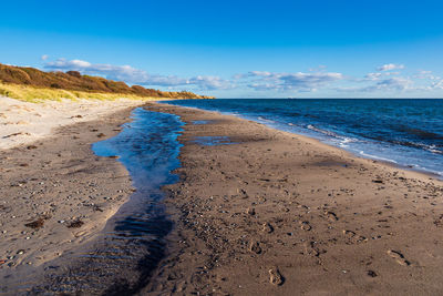 Scenic view of beach against blue sky