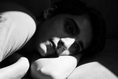 Close-up portrait of young woman lying down