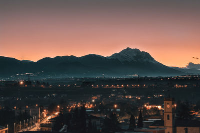 High angle view of illuminated city against sky at sunset