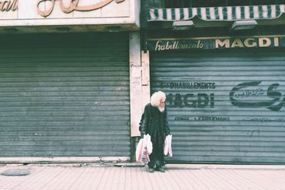 Full length of woman standing against wall