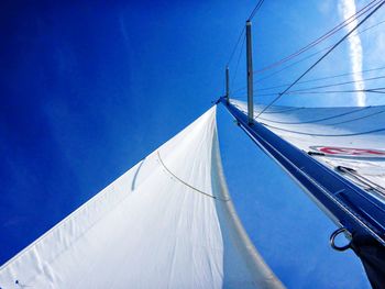 Low angle view of sailboat against blue sky