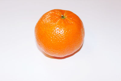 Close-up of orange apple against white background