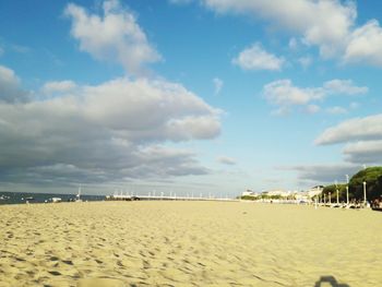 Scenic view of beach against cloudy sky