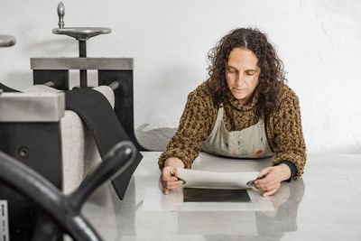 Female artist getting a plate ready for printing using a manual