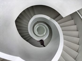 Directly above shot of man climbing a spiral staircase