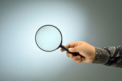 Midsection of person holding bubble against white background