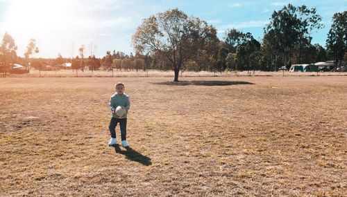 Boy on field against sky