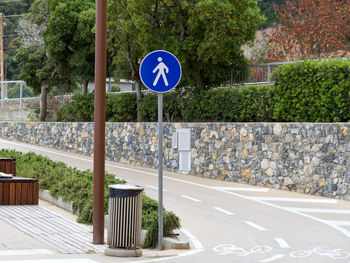 Sign of a pedestrian street next to a bike path on the waterfront of a seaside town