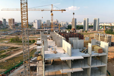 Construction site by buildings against sky in city