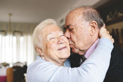 Senior couple hugging and kissing at home