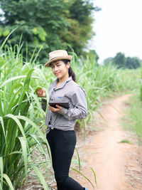 Young woman using phone while standing on land