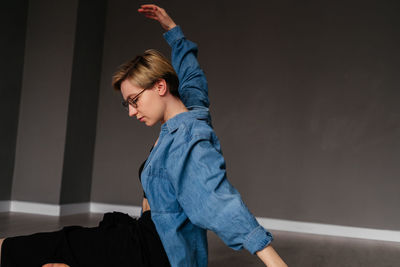 Portrait of young woman standing against wall