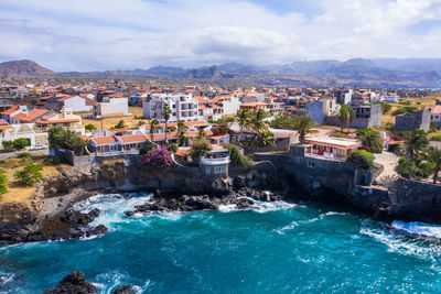 High angle view of buildings by sea against sky