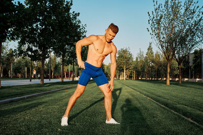 Full length of man exercising on field