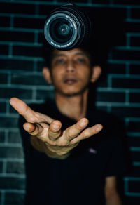 Portrait of young man standing against black background