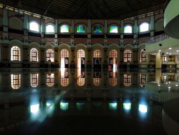 Reflection of illuminated building in swimming pool at night