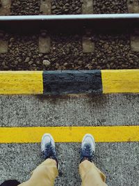 Low section of man standing by railroad track