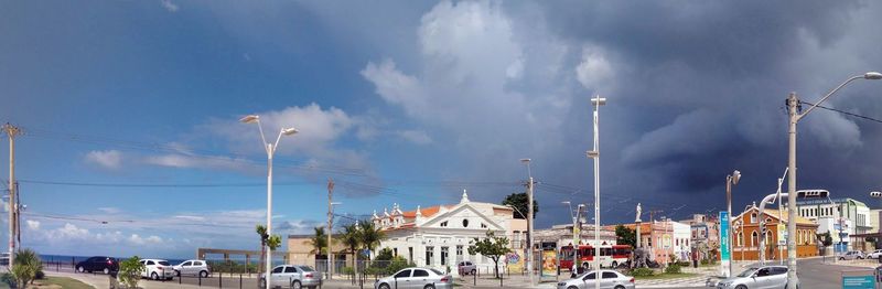 Panoramic view of city street and buildings against sky