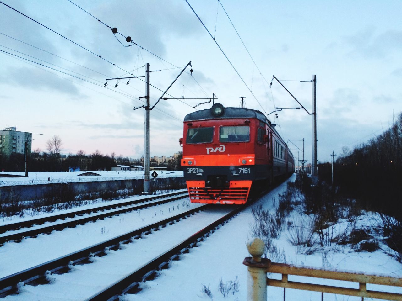 railroad track, transportation, snow, rail transportation, winter, public transportation, electricity pylon, cold temperature, power line, mode of transport, train - vehicle, sky, season, cable, electricity, connection, power supply, weather, railroad station, railroad station platform
