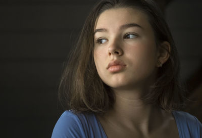 Close-up of innocent girl looking away while sitting at home