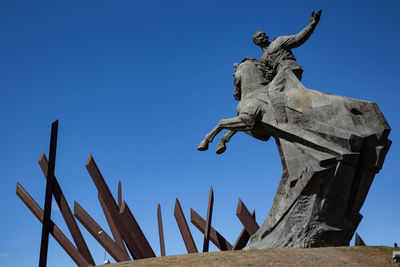 Low angle view of angel statue against clear blue sky