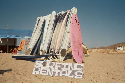 Placard against surfboards on sand at beach