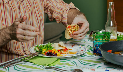 Midsection of woman holding food on table