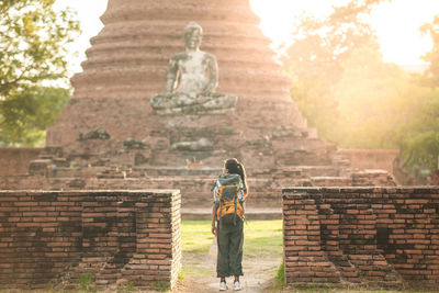 Rear view of woman standing against temple