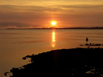 Scenic view of sea against orange sky