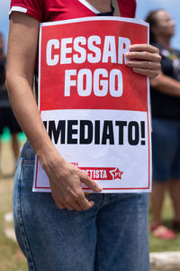 Protesters are seen holding signs during a protest against the war on palestine 