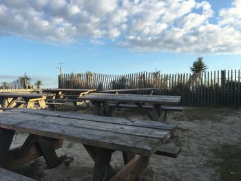 Wooden pier on sea against cloudy sky