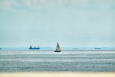 Sailboat sailing on sea against sky